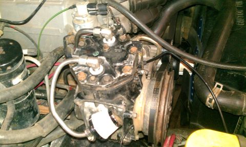 1995 Ford Bronco - Close-up view of an air conditioning compressor assembly, showing the belt and pulley system.
