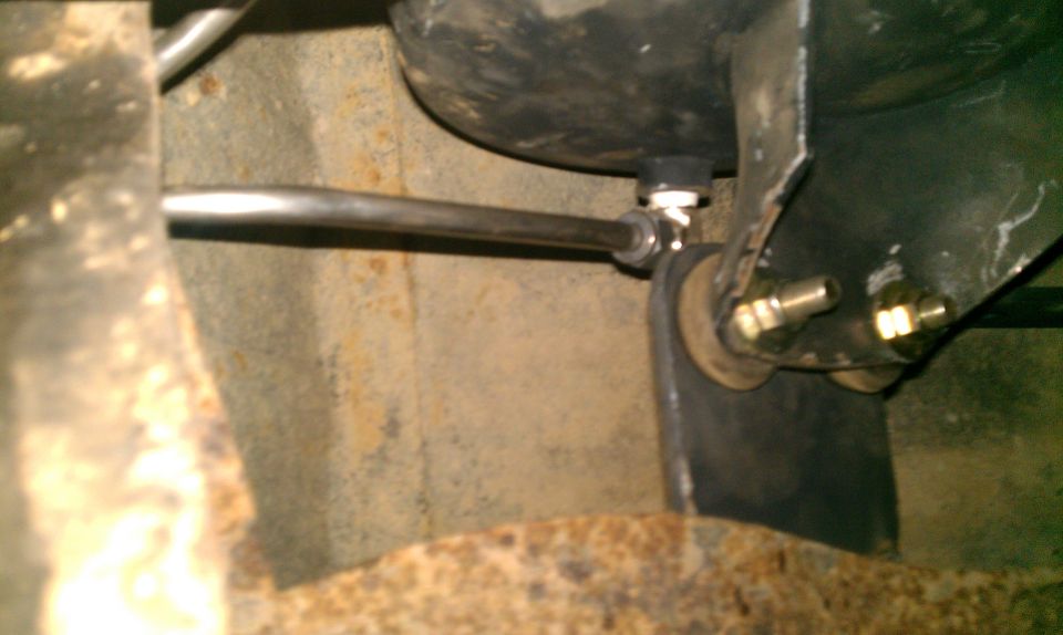 Close-up of an air compressor tank and linkage mounted to a vehicle frame