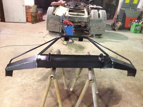 1996 Ford Bronco - A custom front bumper is displayed in a workshop, with a truck chassis visible behind it.