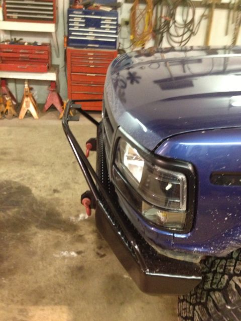 1996 Ford Bronco - A blue pickup truck is parked in a garage with a custom bumper and tow hooks visible.