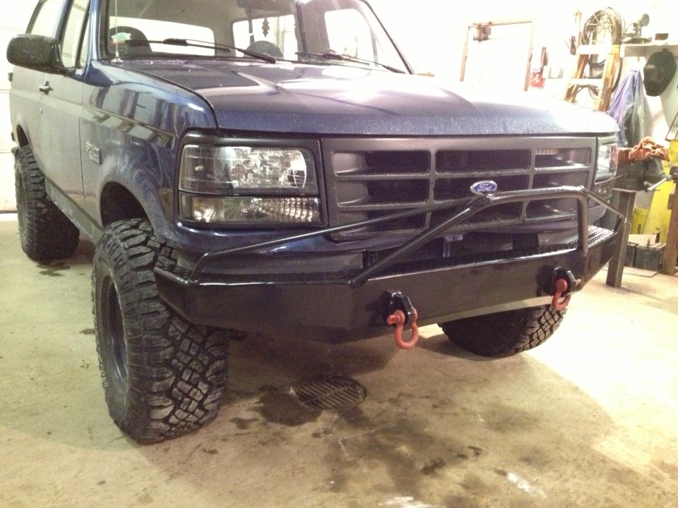 Blue 1996 Ford Bronco front 3/4 view with aftermarket bumper and off-road tires