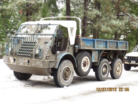 1989 Ford Bronco - A weathered six-wheeled military truck sits in the snow, with another vehicle visible in the background.