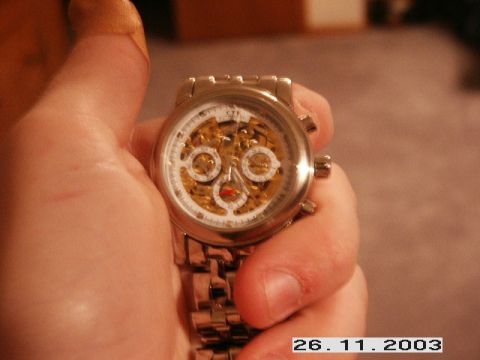 1998 Mercury Sable - A close-up of a mechanical watch with exposed inner workings is held in a person's hand.