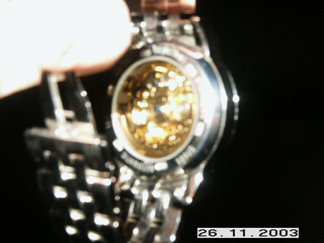 Close-up of a watch with a gold-colored mechanical movement visible