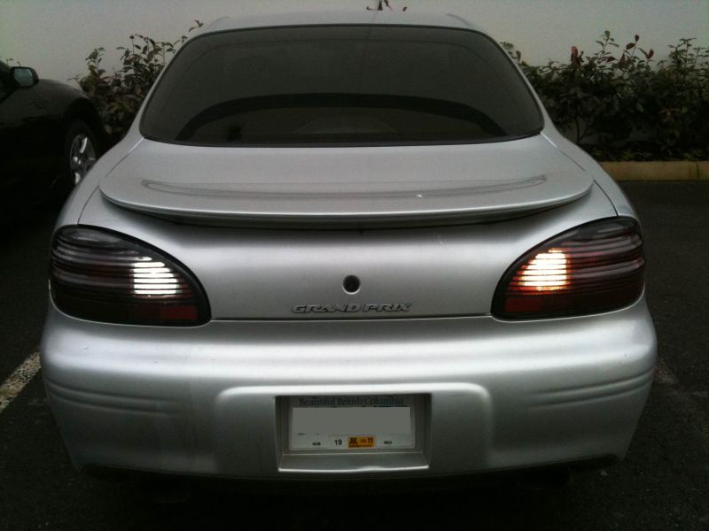 Silver 2002 Pontiac Grand Prix rear view with illuminated backup lights