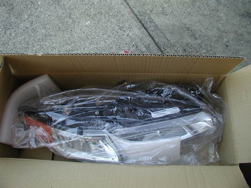 Headlight assembly in plastic wrap inside a cardboard box