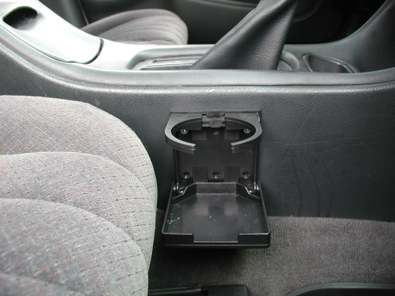 Folding cup holder in a 2002 Pontiac Grand Prix interior, next to a gray patterned seat