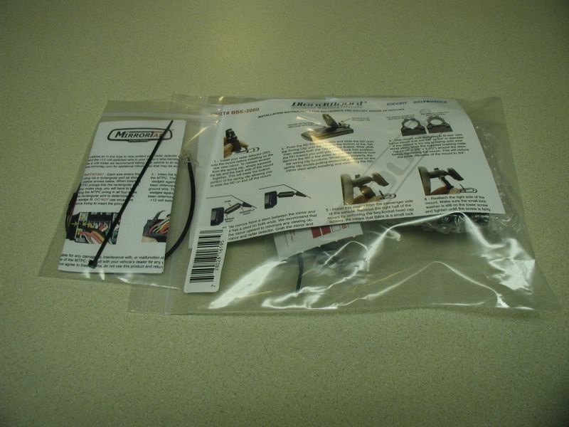 Two plastic bags containing instructions and parts for a radar detector mount