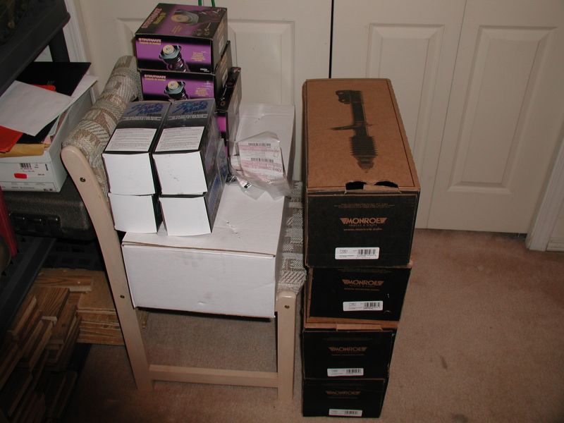Stack of boxes containing Monroe brand car suspension parts, some labeled