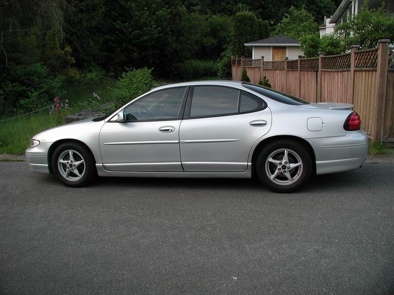 Silver 2002 Pontiac Grand Prix sedan parked on asphalt, side view