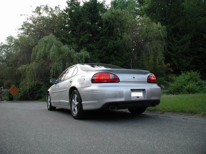 2002 Pontiac Grand Prix rear view, silver, parked on asphalt road with trees in background