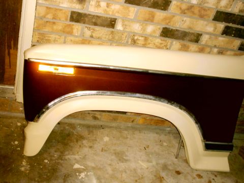 1980 Ford Bronco - A two-tone fender, brown and cream, with an amber turn signal and chrome trim, is shown.