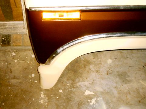 1980 Ford Bronco - Close-up of a brown and white fender with an amber turn signal, consistent with a 1980 Ford Bronco.