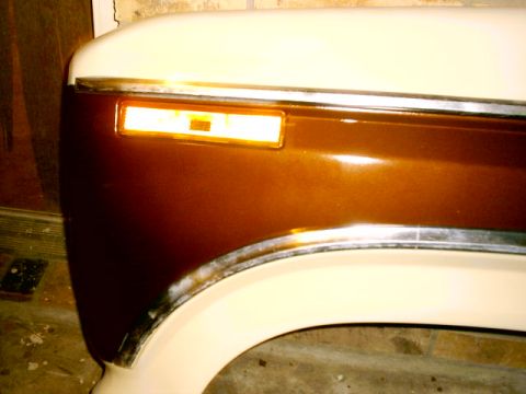 1980 Ford Bronco - Detail of a vehicle's fender and turn signal light assembly, showing chrome trim.