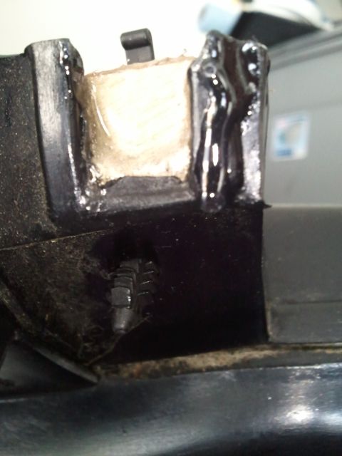 1994 Ford Bronco - A close-up view shows a repaired section of a black plastic automotive component with a foam insert and sealant.