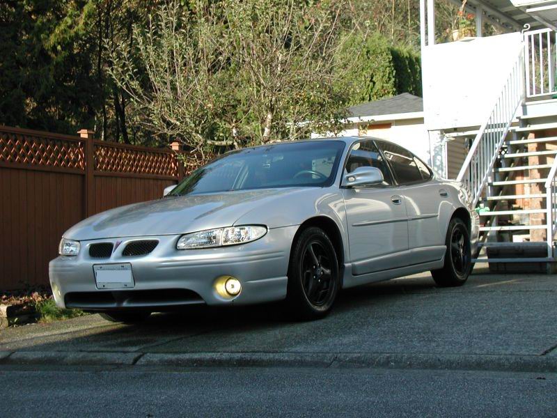 Silver 2002 Pontiac Grand Prix sedan parked on a driveway with black wheels