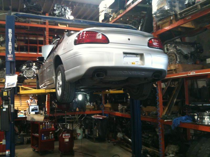 Silver 2002 Pontiac Grand Prix rear view on a lift in a repair shop