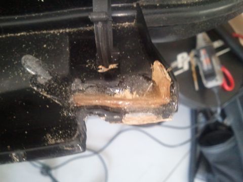 1994 Ford Bronco - A close-up view shows damage to a black plastic component, revealing exposed wood underneath.