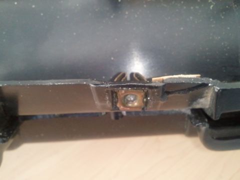 1994 Ford Bronco - Close-up of a vehicle's interior dashboard mounting bracket, showing a metal clip and screw attachment.