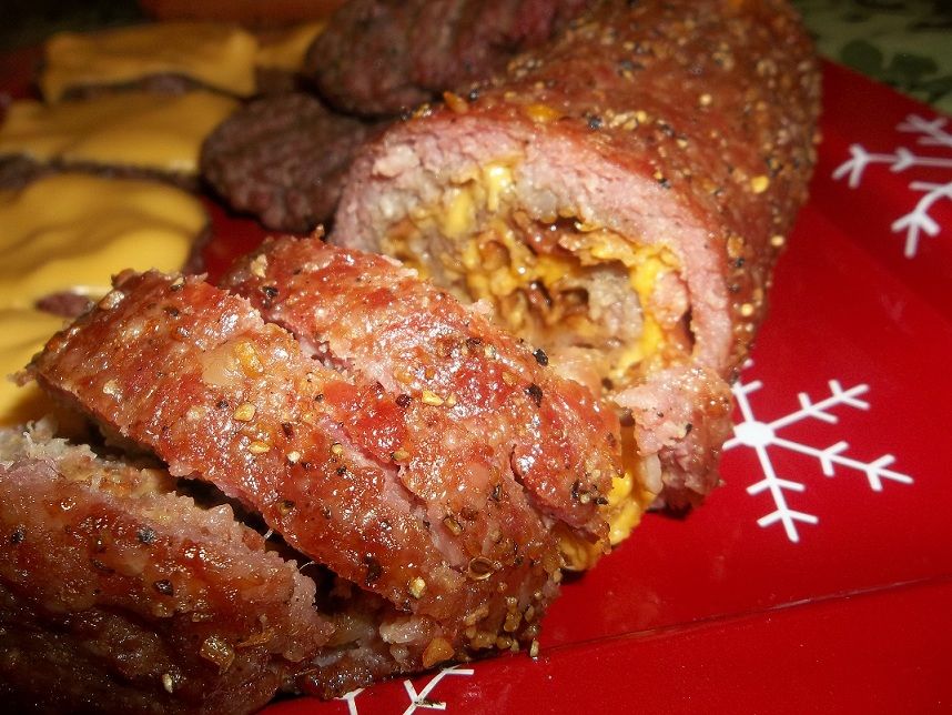 Stuffed meatloaf sliced on a red plate with snowflake designs, next to cheeseburgers