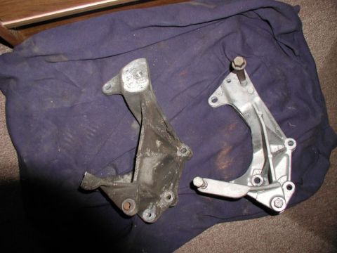 1990 Ford F-250 - Comparison of a used and a new alternator bracket, likely for a Ford truck.
