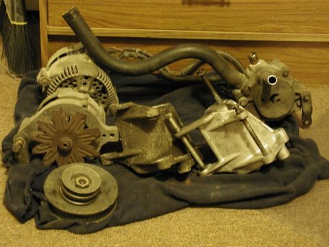 1990 Ford F-250 - This image shows an alternator and power steering pump assembly laid out on a dark cloth.