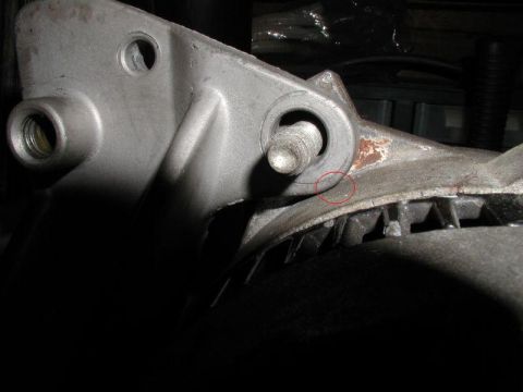1990 Ford F-250 - A close-up view of a metal alternator bracket shows a crack and signs of rust.