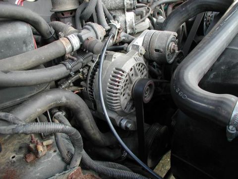 1990 Ford F-250 - Close-up view of the alternator and associated engine hoses.