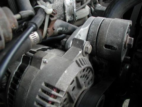 1990 Ford F-250 - Engine bay detail showing an alternator and associated plumbing.