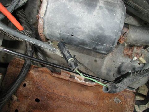 1990 Ford F-250 - Close-up view of a vehicle's engine bay wiring harness, showing green wires and a black connector. The registry label may be incorrect.