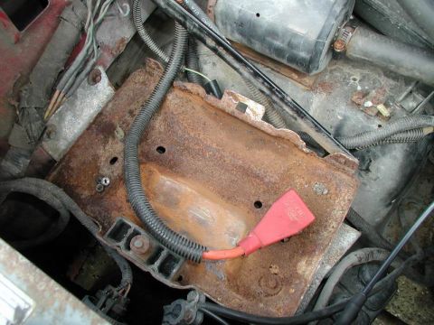 1990 Ford F-250 - The battery tray and surrounding engine components show significant rust and wear.