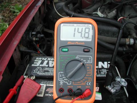 1990 Ford F-250 - Multimeter reads 14.8 volts while connected to a car battery, likely testing the alternator output.