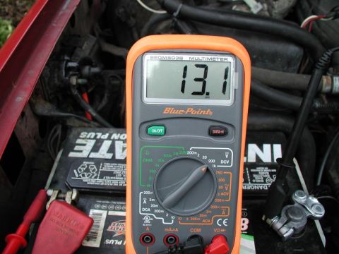1990 Ford F-250 - A multimeter displays 13.1 volts while connected to a vehicle's battery terminals.