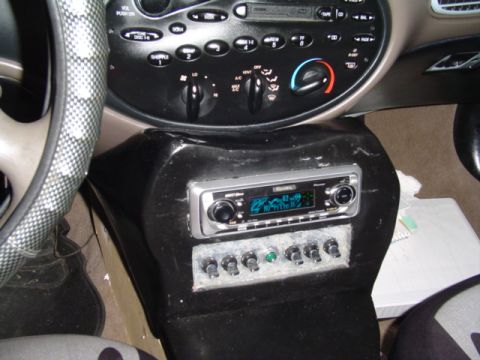 1999 Ford Taurus - Interior view of a car's dashboard, highlighting the central console with an aftermarket stereo and auxiliary switches.