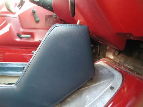1990 Ford F-250 - Close-up interior view of a dark blue center console with visible stitching and a metal trim piece.