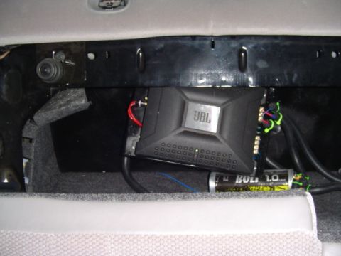 1999 Ford Taurus - A JBL amplifier and capacitor are visible, installed within the vehicle's interior, likely in the trunk area.