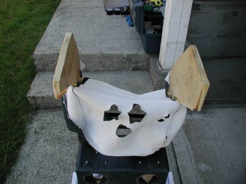 1990 Ford F-250 - Center console section with white upholstery and cutouts, supported by wooden pieces.