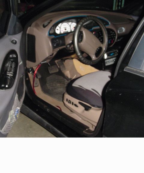 1999 Ford Taurus - The interior of a car is visible, showing the dashboard, steering wheel, and seats.