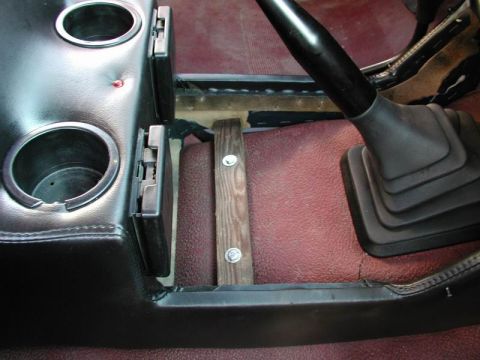 1990 Ford F-250 - Interior view of a vehicle's center console, showing cup holders and a gear shifter, with a makeshift wooden support.