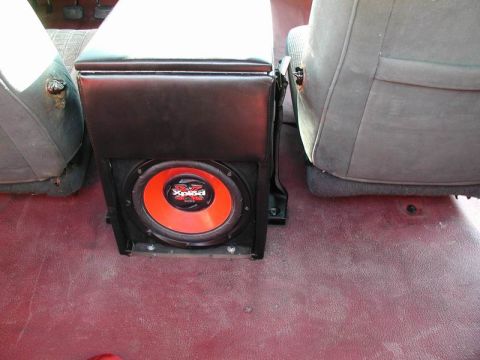 1990 Ford F-250 - Aftermarket center console with a subwoofer installed between the vehicle's seats.