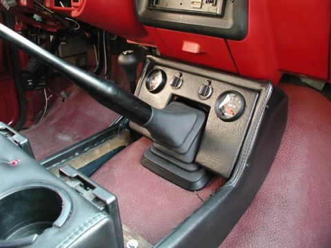 1990 Ford F-250 - The center console of a vehicle features a shifter, transfer case lever, and auxiliary gauges.