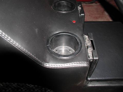 1990 Ford F-250 - Close-up of a vehicle's center console, showing two cup holders and a small red light.