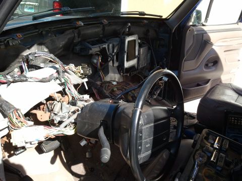 1994 Ford Bronco - The interior of a 1994 Ford Bronco shows a disassembled dashboard with a complex network of exposed wiring and the steering wheel.