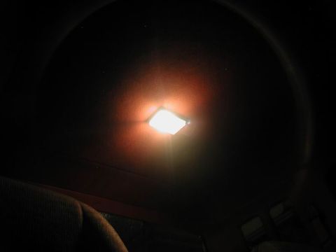 1990 Ford F-250 - The interior dome light is on in a dark vehicle cabin, with a seat visible in the foreground.