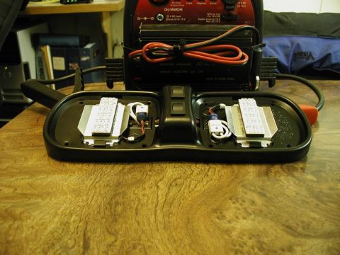 1990 Ford F-250 - Disassembled dome light assembly and battery charger on a wooden surface.