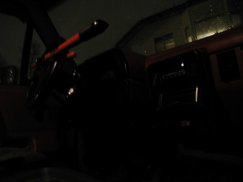 Interior shot of a vehicle, showing the steering wheel and dashboard area in low light