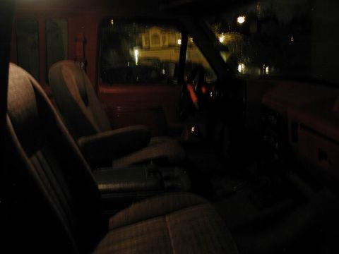 1990 Ford F-250 - The interior of a truck is visible, showing the seats and dashboard in low light conditions.