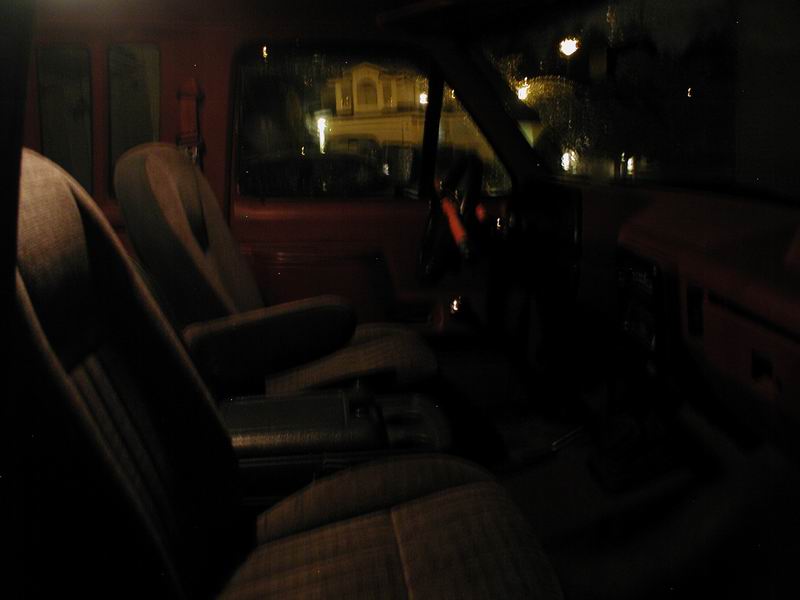 Interior view of truck seats and dashboard at night