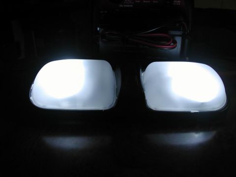 1990 Ford F-250 - The photo shows two illuminated dome lights, likely from a vehicle's interior, with some electronic equipment in the background.