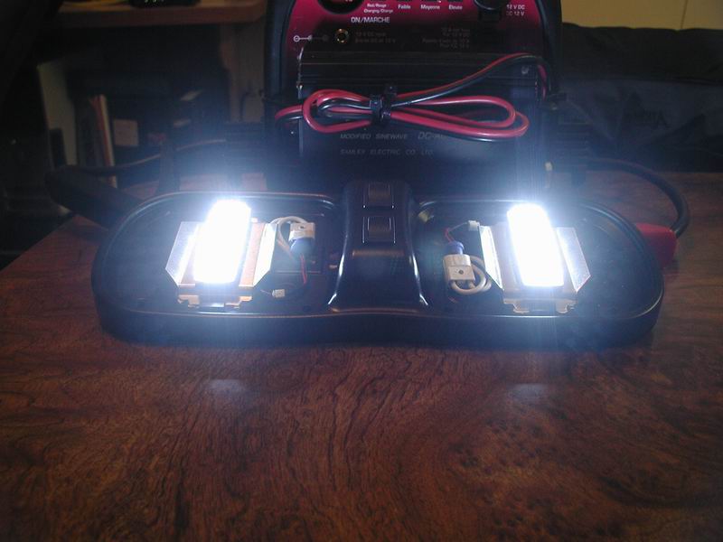Domelight with two bright LED bulbs and a central switch, connected to a battery charger